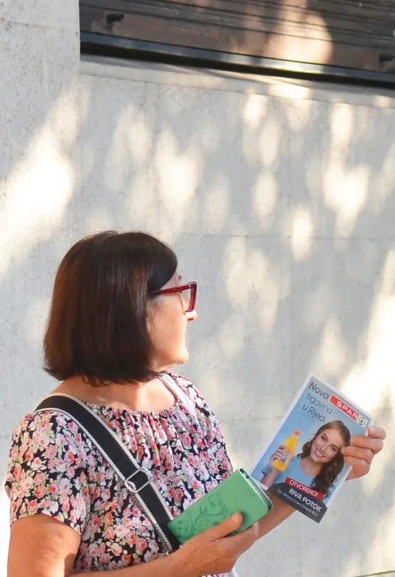 Street flyer distribution – a passer-by reading the flyer she was handed